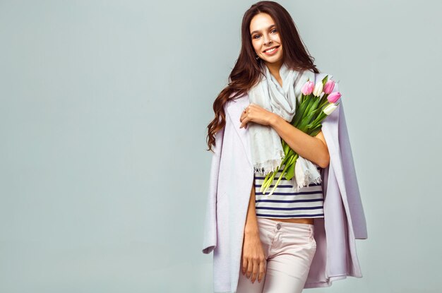 Foto de moda de una mujer hermosa con tulipanes en la mano 8 de marzo niña hermosa con ropa elegante