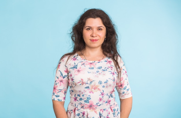 Foto de moda de una mujer joven con el pelo rizado con un vestido blanco