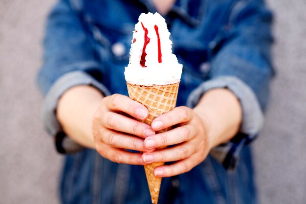 Foto de moda de primer plano al aire libre de chica hipster comiendo helado en clima cálido de verano