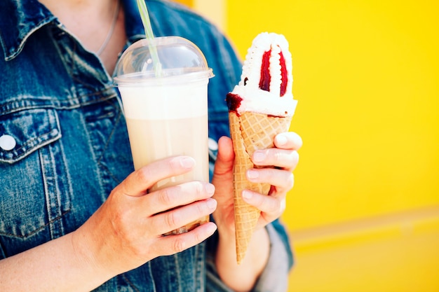 Foto de moda de primer plano al aire libre de chica hipster comiendo helado en clima cálido de verano