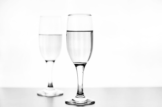 Foto monocromática de champanhe na mesa branca sobre fundo branco isolado