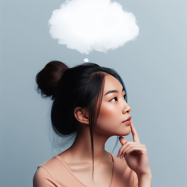 Foto de una morena pensativa sosteniendo su barbilla y mirando hacia arriba con una nube de pensamientos dibujada sobre su cabeza