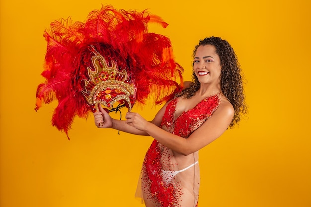 Foto de mujer afro vestida para el carnaval con traje de bailarina sosteniendo su corona en la mano.