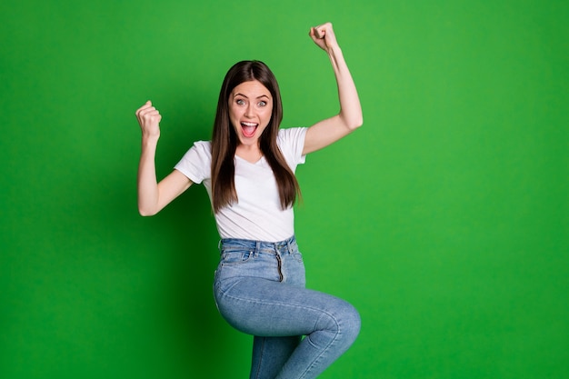 Foto de mujer alegre ganadora vestida con traje casual con los brazos abiertos boca abierta fondo de color verde aislado