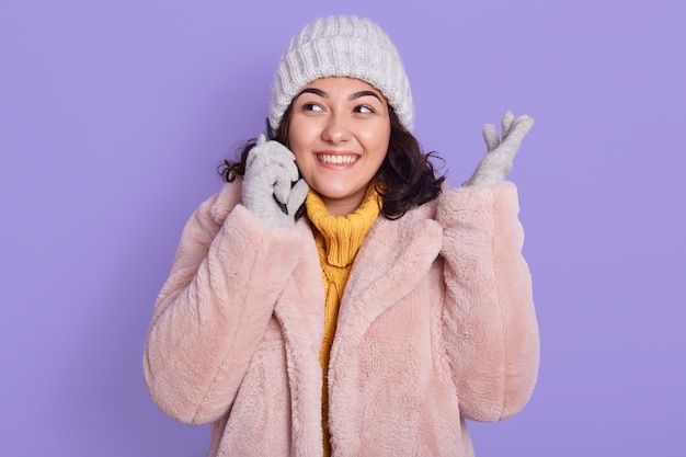 Foto de mujer bonita alegre hablando por teléfono y escuchando noticias frescas