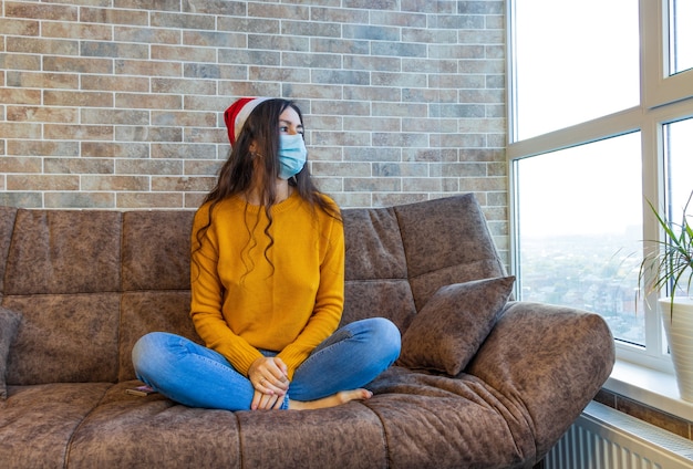 Foto de mujer bonita divertida vacaciones de invierno ropa de ensueño gorro de santa claus suéter de punto color amarillo