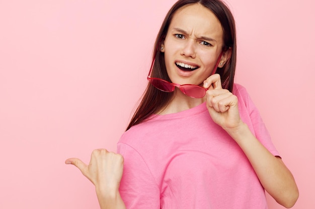 Foto mujer bonita en gafas elegantes posando emociones fondo rosa