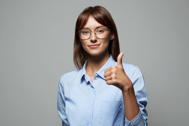 Foto de una mujer bonita con gafas mostrando el dedo