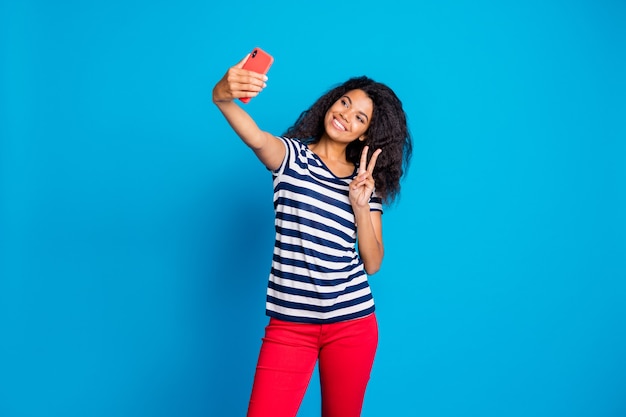 Foto de mujer bonita linda alegre mantenga teléfono tomando selfie mostrando signo v