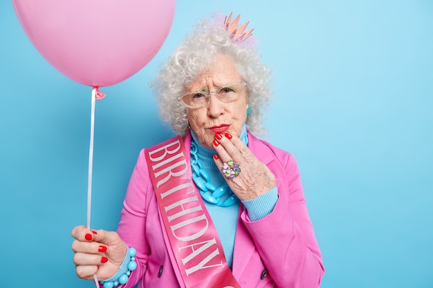 Foto de mujer europea arrugada disgustada usa maquillaje y manicura celebra cumpleaños