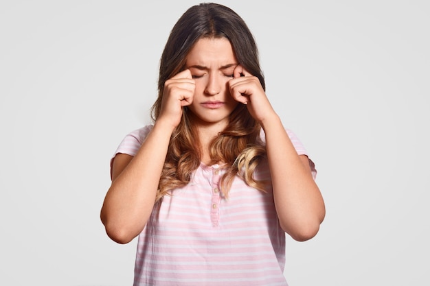 Foto de mujer europea soñolienta frota los ojos