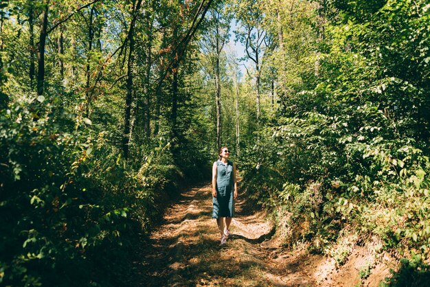 Foto de mujer hermosa joven caminando en el bosque y relajante.