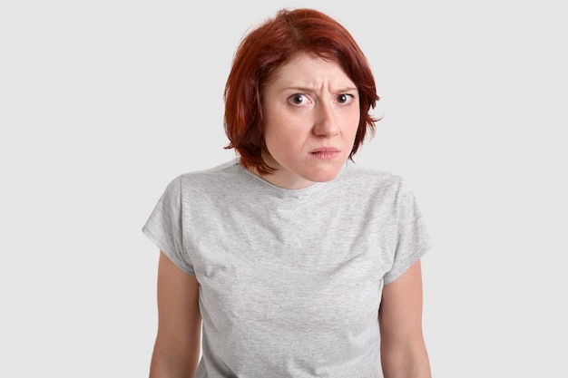 Foto de mujer hermosa pelirroja mira con mirada curiosa