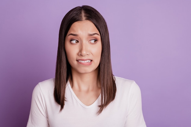 Foto foto de mujer joven infeliz triste malestar negativo mordedura moody labios dientes fallan aislado sobre fondo de color violeta