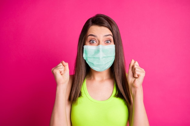 Foto de mujer joven manos puños usan mascarilla verde aislado sobre fondo rosa vibrante