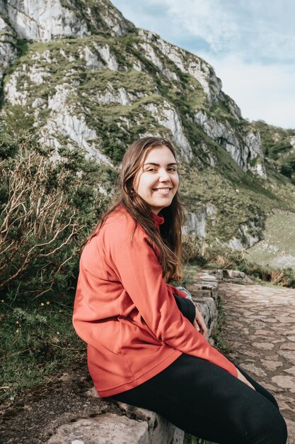 Foto de una mujer joven mirando el paisaje mientras camina en las montañas. Turista de niña en la montaña. Fitness recreativo y estilo de vida saludable al aire libre en la hermosa naturaleza