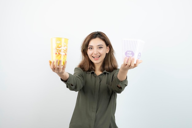 Foto de mujer joven en ropa casual con cajas de palomitas de maíz de pie. foto de alta calidad