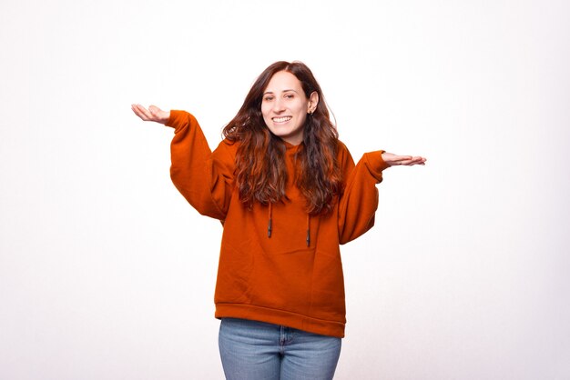 Foto de una mujer joven sonriendo a la cámara y mostrando gesto de no sé