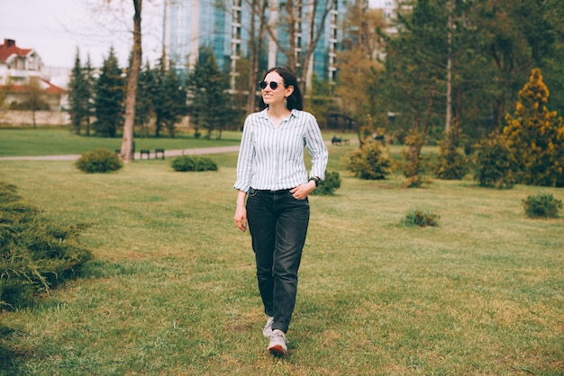 Foto de mujer de negocios joven caminando en el parque durante el tiempo libre