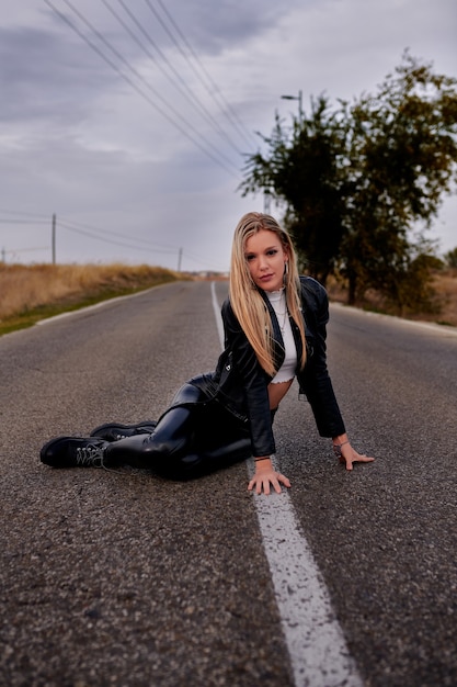 Una foto de una mujer de Oriente Medio sentada en una carretera