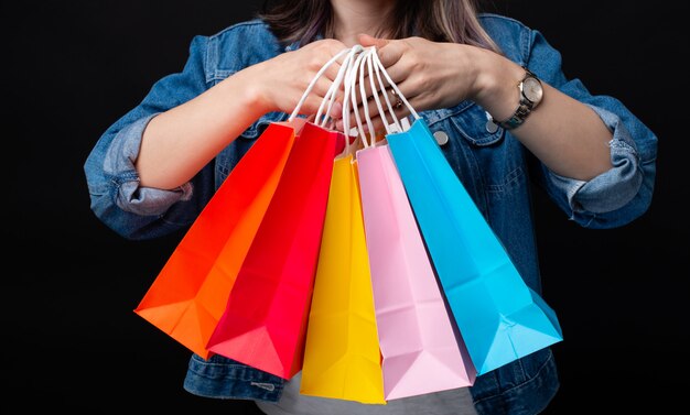 Foto de mujer sosteniendo muchos coloridos bolsos de compras de cerca