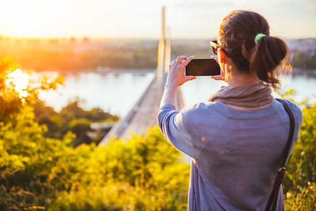 Foto de mujer tomando al aire libre con teléfono inteligente