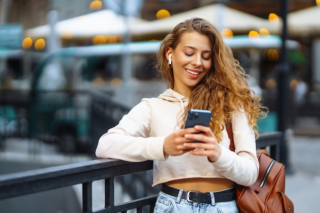 Foto de una mujer usando un teléfono inteligente Una mujer enviando mensajes de texto en la calle Una mujer hermosa pasando tiempo en la ciudad