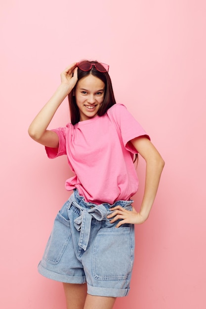 Foto mulher bonita, óculos cor de rosa e camiseta, gesto de mão, fundo rosa