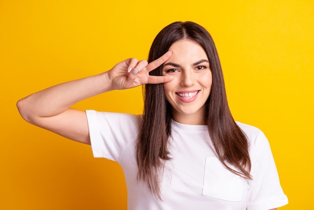 Foto de niña bonita diviértete engañando mostrar paz cool vssymbol aislado sobre fondo de color amarillo