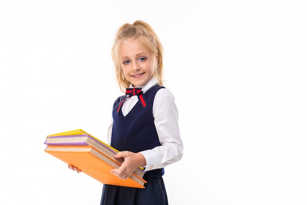 Foto de una niña con cabello rubio mantiene libros