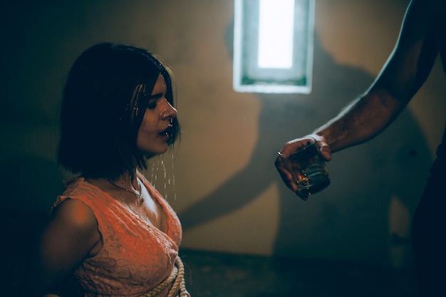 Una foto de una niña sentada atada con cuerdas.