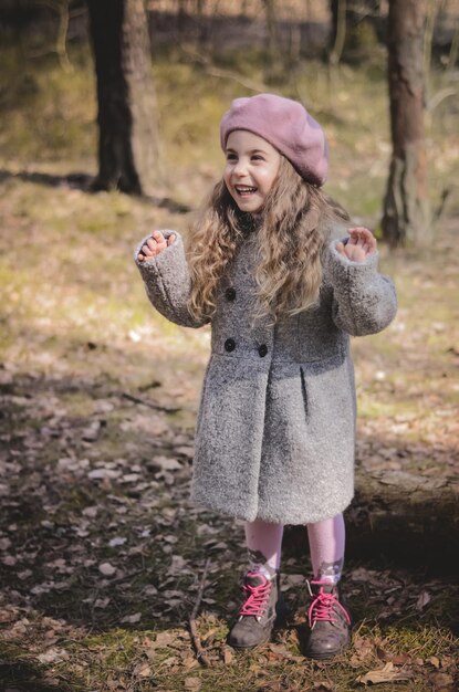 Foto de niña vestida de estilo vintage jugando en el bosque