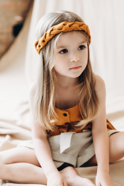 Foto de una niña vestida con ropa de lino elegante a la luz del día