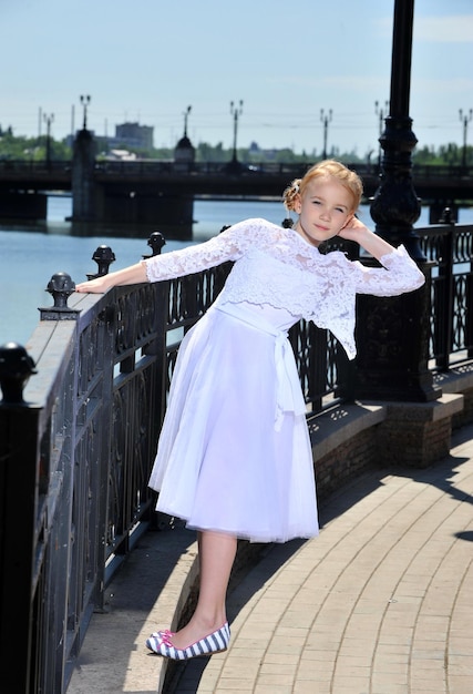 foto de una niña con vestido blanco posando al aire libre