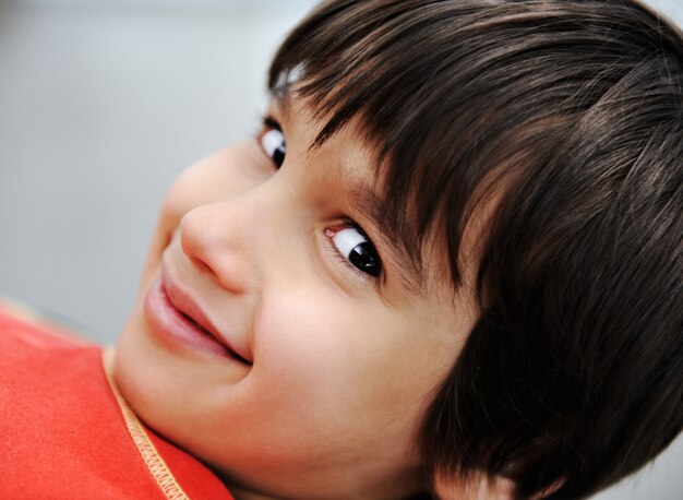 Foto foto del niño adorable que mira la cámara