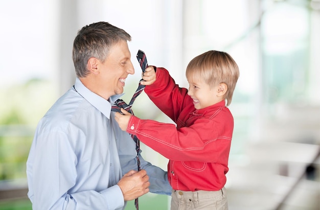 Foto de niño ayudando a su padre a atar la corbata