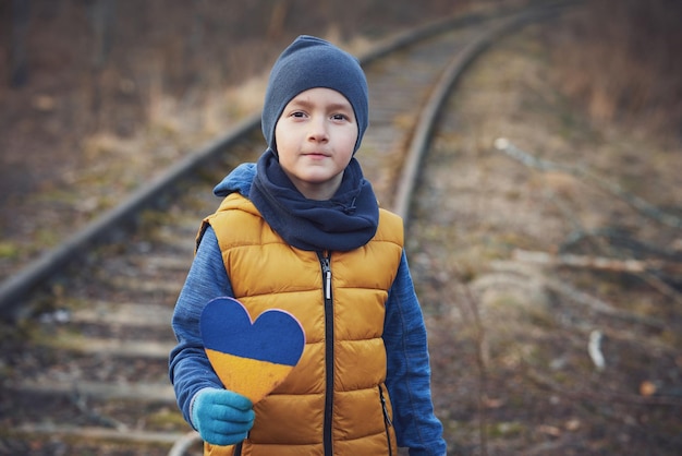 Foto de un niño con mucho amor y un mensaje de paz sosteniendo el corazón Foto de alta calidad