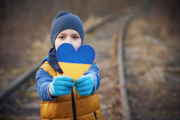 Foto foto de un niño con mucho amor y un mensaje de paz sosteniendo el corazón foto de alta calidad