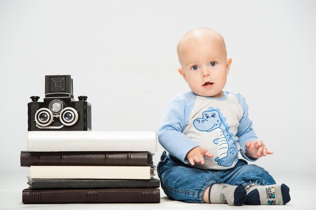 Foto de un niño pequeño que sostiene una cámara de película vieja