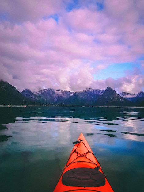 Foto de noruega con mar cielo nublado barco naranja en la noche de verano