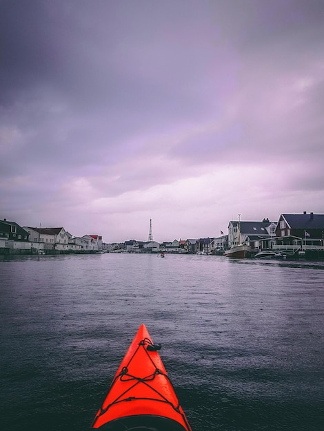 Foto de noruega con río cielo nublado barco naranja en la noche de verano