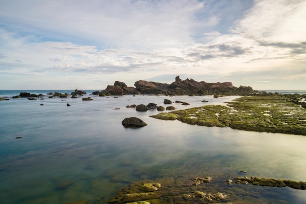 Una foto del océano y las rocas en la playa.