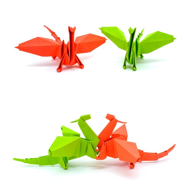 Foto de origami dragones verdes y rojos aislado sobre fondo blanco.