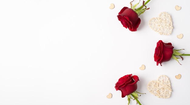Foto-Overhead von Rosen Herzen und Konfetti auf dem weißen Hintergrund isoliert