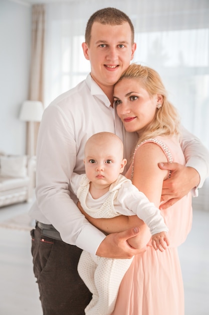 Foto de padre abraza a su esposa e hijo. Familia feliz, mirar cámara del juez