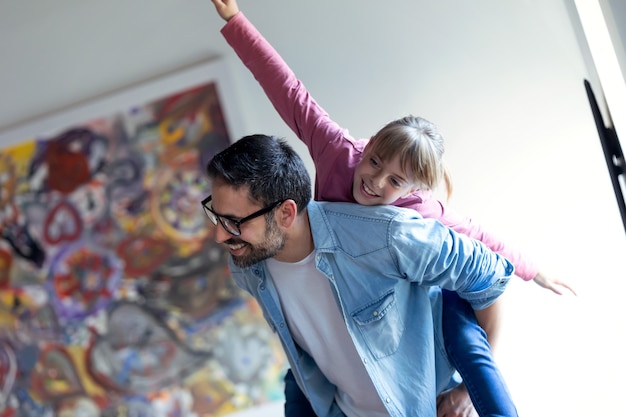 Foto de padre joven y guapo con su hija bonita disfrutando de tiempo juntos en casa.