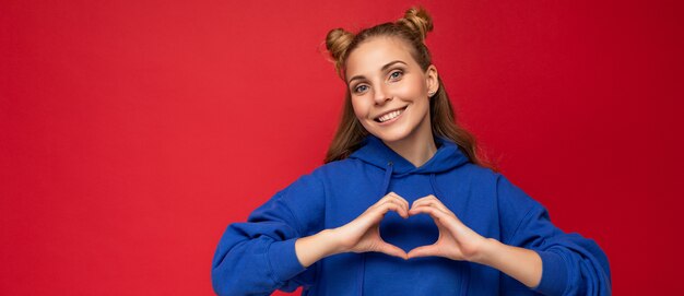 Foto panorámica de la joven mujer rubia atractiva positiva feliz con dos cuernos con emociones sinceras