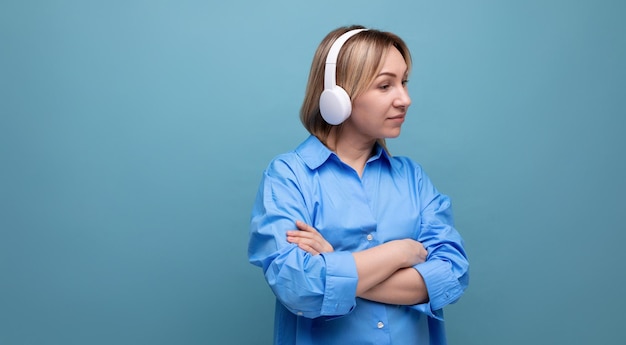 Foto de pantalla ancha de una chica europea pensativa en una camisa casual escuchando música en blanco grande