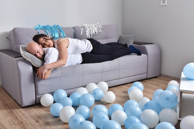 Foto de pareja de familia caucásica romántica alegre sonriendo y abrazándose mientras está sentado en el sofá en casa. Hombre y mujer, enamorado