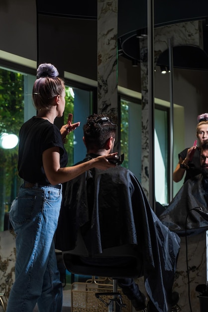 Una foto de un peluquero cortando el cabello de un cliente guapo Estilista sirviendo a un cliente en la peluquería